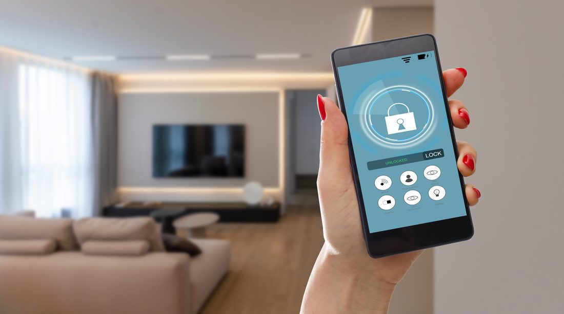Hand holding a smartphone displaying a home security app in a Montclair home.